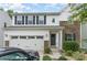 Charming two-story home featuring a white exterior, stone accents, and a two-car garage with landscaped front yard at 6726 Carradale Way, Charlotte, NC 28278