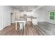 A modern kitchen with granite countertops, stainless steel appliances, a kitchen island, and wood-look floors at 6726 Carradale Way, Charlotte, NC 28278
