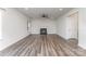 A spacious living room featuring wood-look floors, a fireplace, ceiling fan, and plenty of natural light at 6726 Carradale Way, Charlotte, NC 28278
