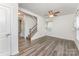 Spacious living room featuring wood-look floors, a staircase, and ample natural light through the windows at 6726 Carradale Way, Charlotte, NC 28278