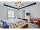 Comfortable bedroom featuring a ceiling fan, a blue accent, and a patterned bedspread at 6821 Millingden Ct, Charlotte, NC 28277