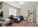 Cozy bedroom features a small desk, a single bed, and a large window for natural light at 6821 Millingden Ct, Charlotte, NC 28277