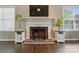 Cozy living room with brick fireplace, decorative mantel and dark wood floors at 6821 Millingden Ct, Charlotte, NC 28277
