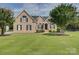 Charming brick home featuring a manicured lawn, mature trees, and classic black shutters at 736 Creekbridge Dr, Rock Hill, SC 29732