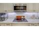 Close-up of kitchen cooktop with modern appliances, marble backsplash, and ample counter space at 736 Creekbridge Dr, Rock Hill, SC 29732