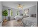 Bright bedroom with two beds, ceiling fan, light colored walls, and natural light from two windows at 7830 Sarah Dr, Denver, NC 28037