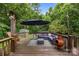 Outdoor deck with patio furniture, umbrella, a chiminea, string lights and a beautiful wooded background at 7830 Sarah Dr, Denver, NC 28037