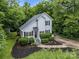 Aerial view of charming home with lush landscaping, a side deck, and a concrete driveway at 7830 Sarah Dr, Denver, NC 28037
