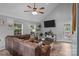 Bright living room featuring a comfortable sectional couch, and a ceiling fan at 7830 Sarah Dr, Denver, NC 28037