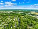 An aerial view of a neighborhood with dense trees and scattered houses under a blue sky at 8020 Sheckler Ln, Matthews, NC 28104