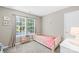 Bedroom featuring a small bed with pink blanket next to a window with curtains at 8020 Sheckler Ln, Matthews, NC 28104