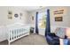 Cozy bedroom showcasing a crib and a comfortable chair under a bright window at 8020 Sheckler Ln, Matthews, NC 28104