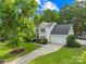 Beautiful two-story home with a well-manicured lawn, mature trees, and a two car attached garage at 8020 Sheckler Ln, Matthews, NC 28104