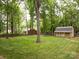 Secluded backyard featuring mature trees, a storage shed, and well-maintained lawn at 8201 Lansford Rd, Charlotte, NC 28277