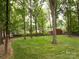 Expansive, lush backyard surrounded by mature trees and a classic wooden fence at 8201 Lansford Rd, Charlotte, NC 28277