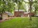 Expansive backyard featuring a storage shed and patio area at 8201 Lansford Rd, Charlotte, NC 28277