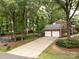 Long driveway leading to a two-car garage surrounded by lush trees at 8201 Lansford Rd, Charlotte, NC 28277