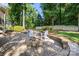 Backyard features a circular stone fire pit, lovely landscaping and mature trees at 9219 Whispering Wind Dr, Charlotte, NC 28277