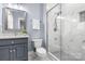 Beautiful bathroom features a glass shower, gray vanity, and white marble tile at 9219 Whispering Wind Dr, Charlotte, NC 28277