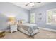 Bedroom with carpet, twin bed, white nightstand, basket, and bright windows at 9219 Whispering Wind Dr, Charlotte, NC 28277