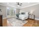 Bedroom features a large window, ceiling fan, hardwood floors, and neutral decor at 9219 Whispering Wind Dr, Charlotte, NC 28277