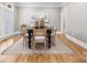 Bright dining room featuring a black table with seating for eight and hardwood floors at 9219 Whispering Wind Dr, Charlotte, NC 28277