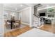 Dining area featuring a black table, seating for eight, and an adjacent living room with stairs at 9219 Whispering Wind Dr, Charlotte, NC 28277