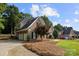 Brick home with a three car garage and a well-kept lawn at 9219 Whispering Wind Dr, Charlotte, NC 28277