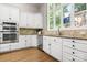 Bright kitchen features white cabinetry, stainless steel appliances, granite countertops, and a large window at 9219 Whispering Wind Dr, Charlotte, NC 28277