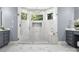 Beautiful shower with white tile, gray accents, multiple windows, and a glass door at 9219 Whispering Wind Dr, Charlotte, NC 28277