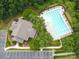 Aerial view of a community pool with ample seating surrounded by lush greenery and convenient parking at 100 Woodwinds Dr, Mount Holly, NC 28120