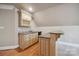 This carpeted loft area includes a stylish wet bar with granite countertops and wooden cabinets at 100 Woodwinds Dr, Mount Holly, NC 28120