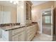 En-suite bathroom vanity featuring marble countertops, and sinks, custom cabinetry, and neutral walls at 100 Woodwinds Dr, Mount Holly, NC 28120