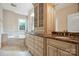 En-suite bathroom vanity featuring marble countertops, and sinks, custom cabinetry, and soaking tub at 100 Woodwinds Dr, Mount Holly, NC 28120