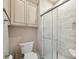 Bathroom featuring tiled shower with glass door, toilet, linen closet, and neutral walls at 100 Woodwinds Dr, Mount Holly, NC 28120