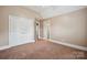A carpeted bedroom with double closets, and access to the bathroom and the landing at the stairs at 100 Woodwinds Dr, Mount Holly, NC 28120