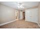 A comfortable bedroom features neutral carpet, ceiling fan, and large double door closet at 100 Woodwinds Dr, Mount Holly, NC 28120