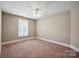 Cozy bedroom with a window with shutters, neutral carpet, and white trim at 100 Woodwinds Dr, Mount Holly, NC 28120