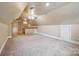 A carpeted bonus room features a wet bar with stylish cabinets and countertop space at 100 Woodwinds Dr, Mount Holly, NC 28120