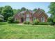 Beautiful brick home with manicured lawn, lush landscaping, and inviting curb appeal at 100 Woodwinds Dr, Mount Holly, NC 28120