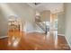 Expansive living room with hardwood floors, grand staircase, and open view to the kitchen at 100 Woodwinds Dr, Mount Holly, NC 28120