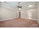Spacious main bedroom featuring tray ceiling, ceiling fan, neutral walls, carpet, and entryways to other rooms at 100 Woodwinds Dr, Mount Holly, NC 28120