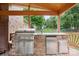 Outdoor kitchen on the deck with built-in grill, sink, and refrigerator, ideal for outdoor cooking at 100 Woodwinds Dr, Mount Holly, NC 28120