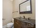 Powder room featuring vanity with decorative accents, granite countertop, and traditional style at 100 Woodwinds Dr, Mount Holly, NC 28120