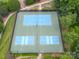 Aerial view of well-maintained tennis courts in a community, surrounded by lush greenery and landscaping at 100 Woodwinds Dr, Mount Holly, NC 28120
