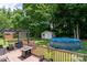 Relaxing backyard oasis featuring a spacious deck, above ground pool, pergola with sunshade, and storage shed at 103 Poplar Trl, Rockwell, NC 28138