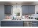Functional kitchen featuring gray cabinets, stainless steel dishwasher, and a bright window over the sink at 103 Poplar Trl, Rockwell, NC 28138
