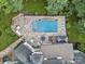 Aerial view of backyard with a rectangular pool, spa, stone patio, and lounge chairs at 10300 Sweetleaf Pl, Charlotte, NC 28278