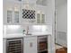 This elegant bar features white cabinets, a wine rack, and two wine coolers for optimal beverage storage at 10300 Sweetleaf Pl, Charlotte, NC 28278