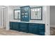 Bathroom featuring double sinks with blue cabinetry, mirrors, and modern fixtures at 10300 Sweetleaf Pl, Charlotte, NC 28278